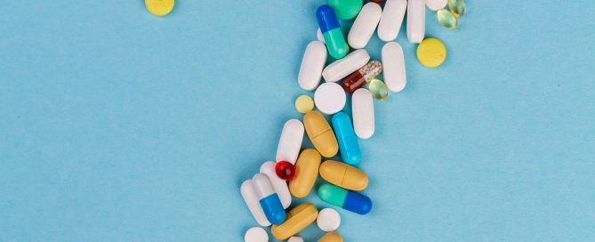 Question mark made of pills laced with fentanyl in front of a blue background