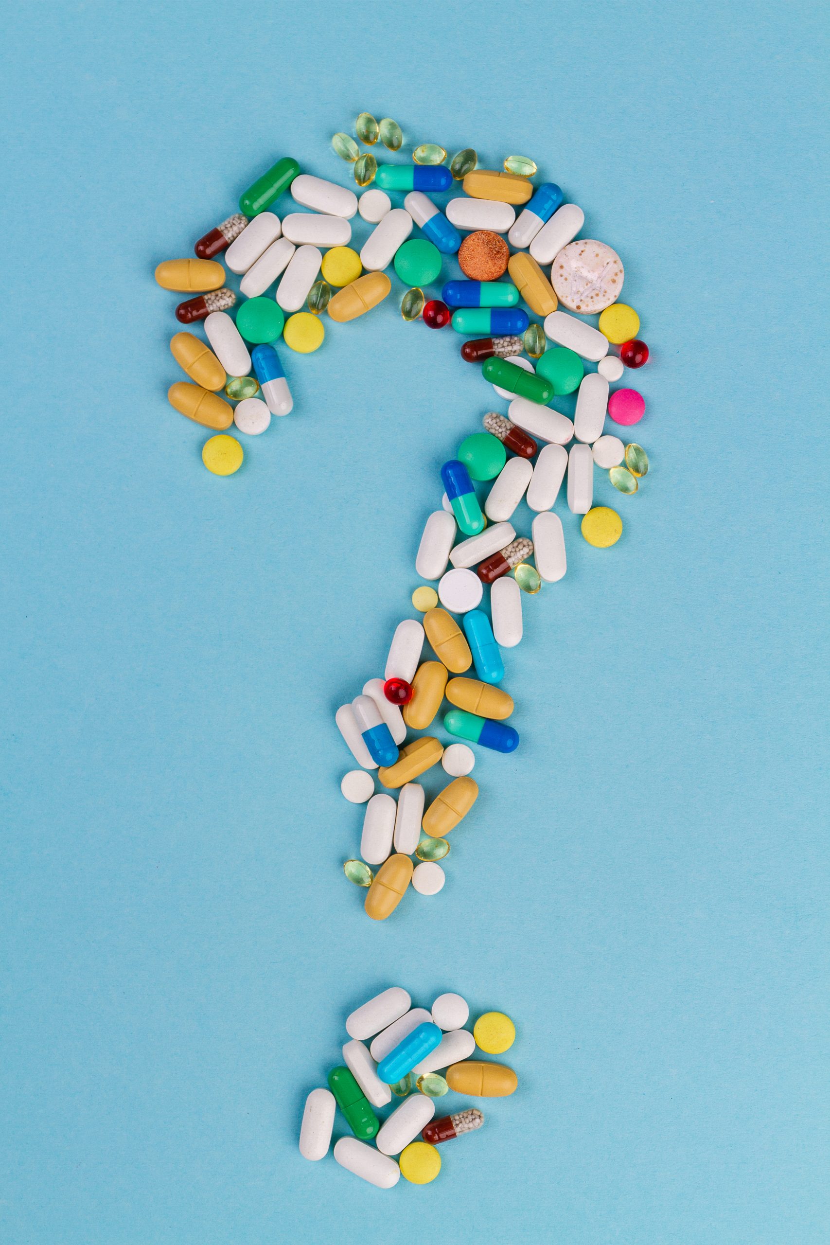 Question mark made of pills laced with fentanyl in front of a blue background