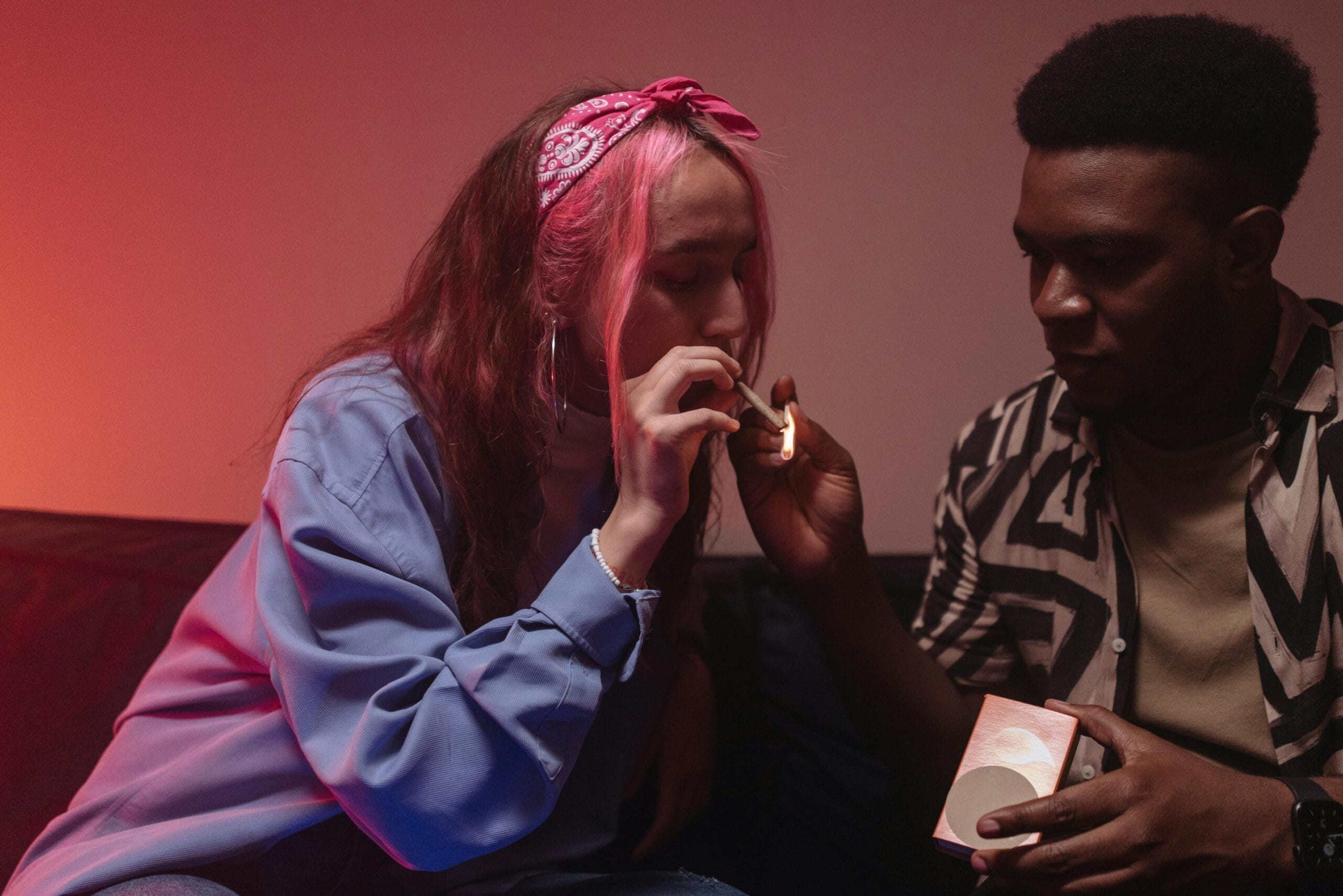 Two people smoking a joint together. 