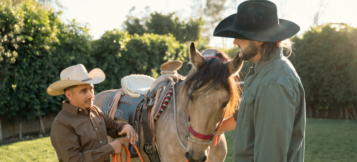 Two individuals engage in equine therapy at Tranquility Recovery Center, interacting with a horse in a serene outdoor setting, fostering emotional connection and healing.