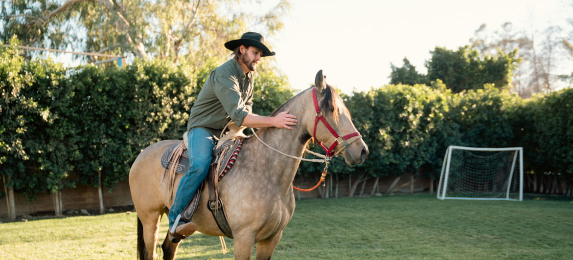 A participant in equine therapy rides a horse at Tranquility Recovery Center's outdoor facility.