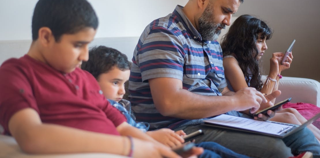 The entire family sitting together, but each looking at their phone 
