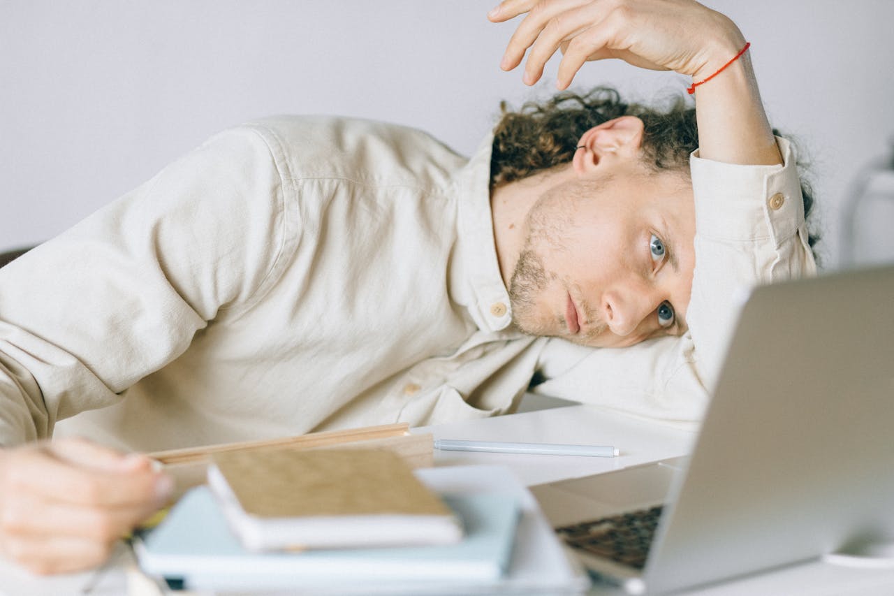 A depressed man, thinking about how to manage alcoholism in the workplace