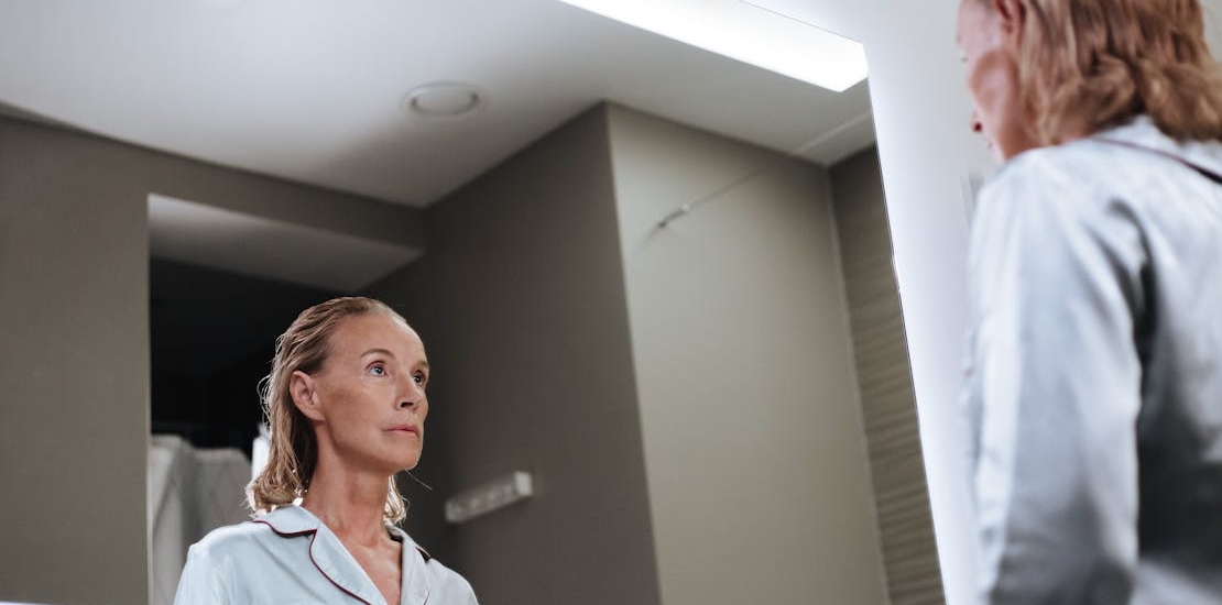 A woman looking herself in the mirror