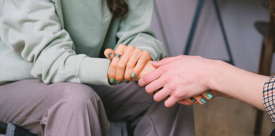 Two women holding hands, talking about what is the experimentation stage of addiction 