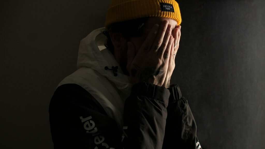 a man hiding his face